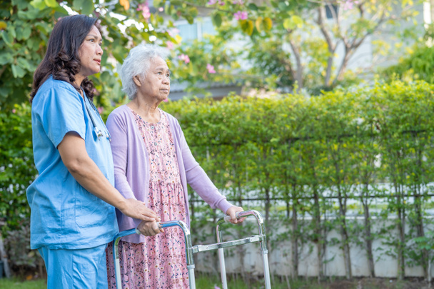Médico ajuda e cuidados Asiático sênior ou idosa senhora uso walker com saúde forte enquanto caminha no parque em feliz feriado fresco. - Foto, Imagem