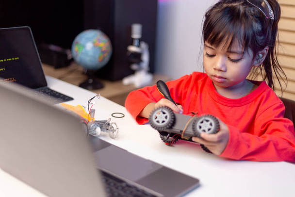 Los estudiantes de Asia aprenden en casa en la codificación de automóviles robóticos y cables de placas electrónicas en STEM, STEAM, matemática ingeniería tecnología código informático en robótica para niños concepto. - Foto, imagen