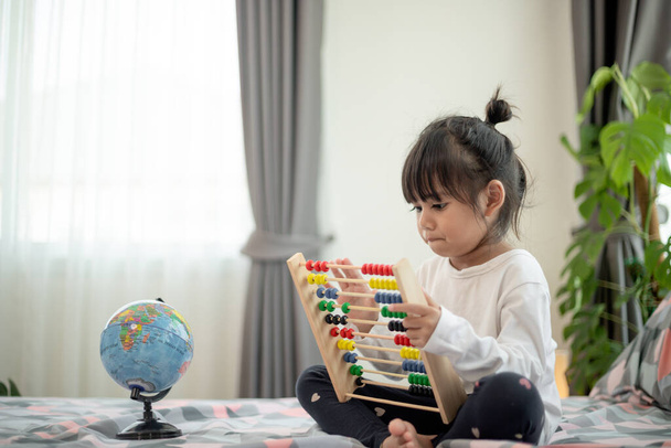 ребенок играет с игрушкой abacus на кровати - Фото, изображение