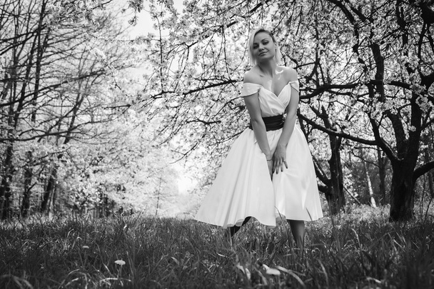 Блондин в белом платье в весеннем саду
 - Фото, изображение