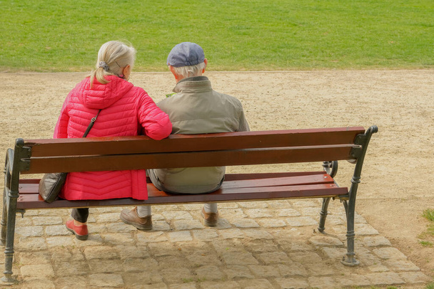 Oldies at the Park . elderly couple sitting on a park bench - Zdjęcie, obraz