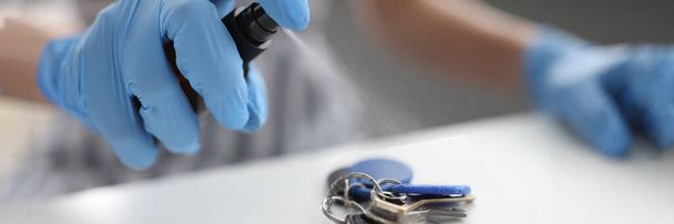 Hands treat keys with sanitizer, close-up - Photo, Image