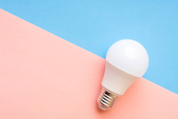 White light bulb on pink and blue background with free copy paste space. - Photo, Image