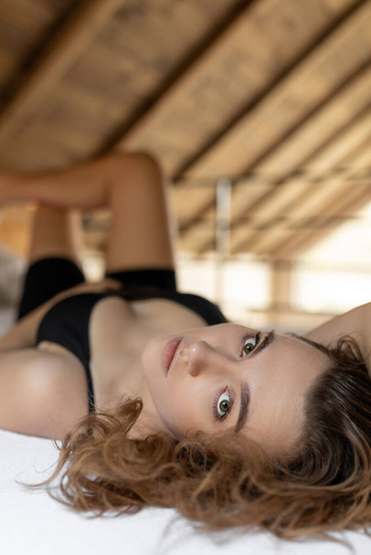 Close - up portrait of young beautiful woman lying on bed and looking at camera . Rest and relaxation. Positive emotions. Natural materials. Beauty and youth. Lifestyle. - Fotografie, Obrázek