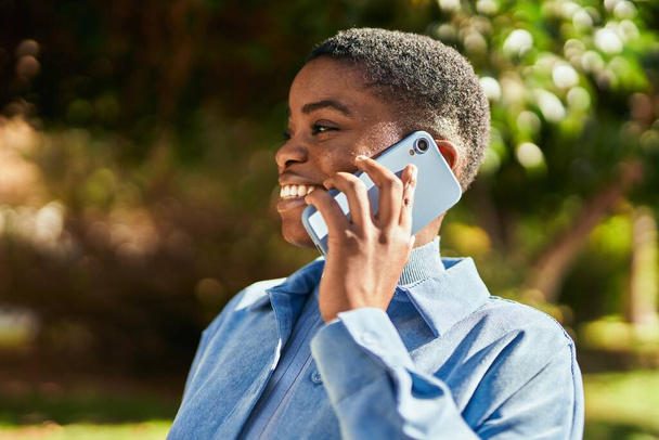 Mladý africký Američan žena usměvavý šťastný mluvení na smartphone ve městě - Fotografie, Obrázek