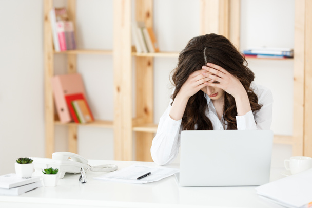 Unavená mladá podnikatelka trpící dlouhou dobu sedí u počítače stolu v kanceláři - Fotografie, Obrázek