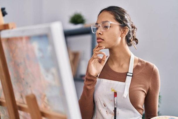 Young african american woman artist with doubt expression drawing at art studio - Фото, зображення