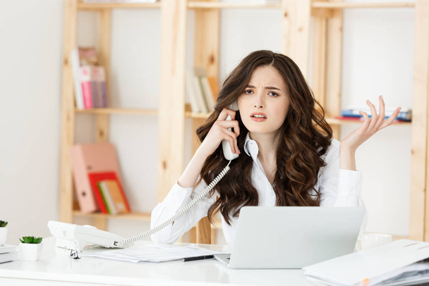 Θυμωμένη επιχειρηματίας που φωνάζει στο τηλέφωνο στο σύγχρονο γραφείο - Φωτογραφία, εικόνα