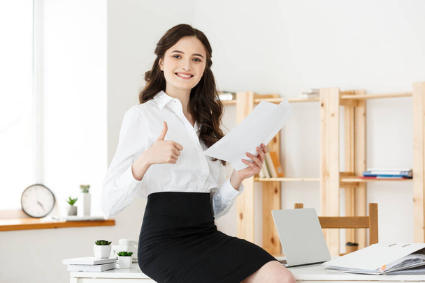 glückliche junge Geschäftsfrau oder Sekretärin mit Dokument im modernen Büro - Foto, Bild