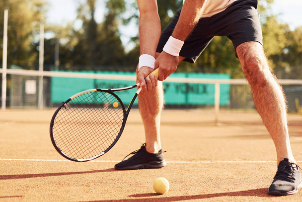 Close up view of senior man in white shirt and black sportive shorts that is on tennis court. - 写真・画像