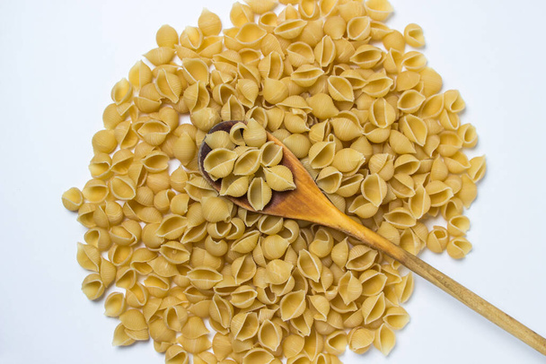 Pasta auf weißem Hintergrund. Nudeln in Muschelform. Traditionelle Lebensmittel - Foto, Bild
