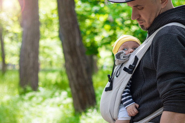 close up de pai carregando seu filho em uma funda de bebê - Foto, Imagem