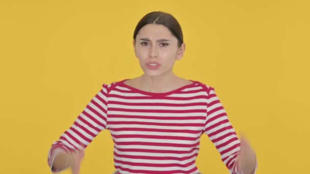 Mujer española decepcionada reaccionando a la pérdida sobre fondo amarillo - Metraje, vídeo