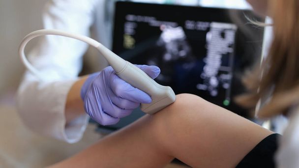 Лікар проводить ультразвукове обстеження колінного суглоба у дитини крупним планом
 - Фото, зображення