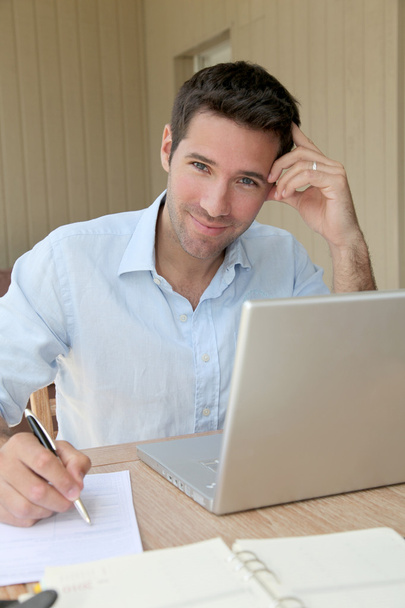 Sorrindo homem trabalhando em casa no computador portátil
 - Foto, Imagem