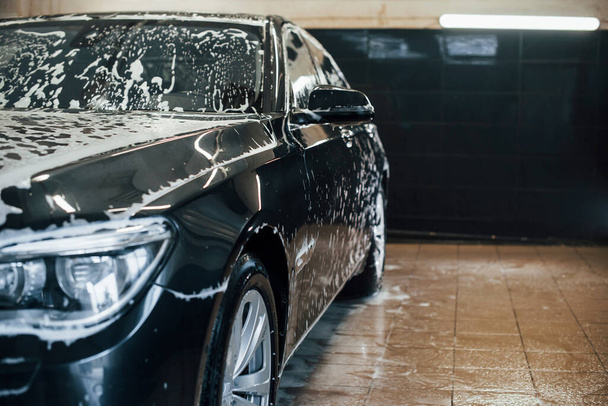 Modern black automobile parked inside of car wash station. - Foto, Imagem