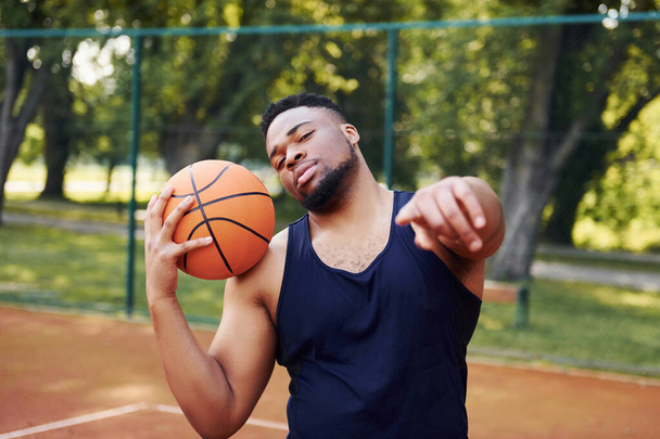 African american man standing with ball on the court outdoors. - Valokuva, kuva