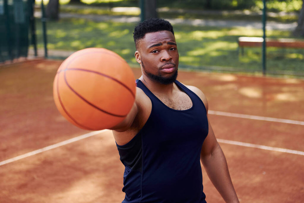 African american man standing with ball on the court outdoors. - Foto, Imagem