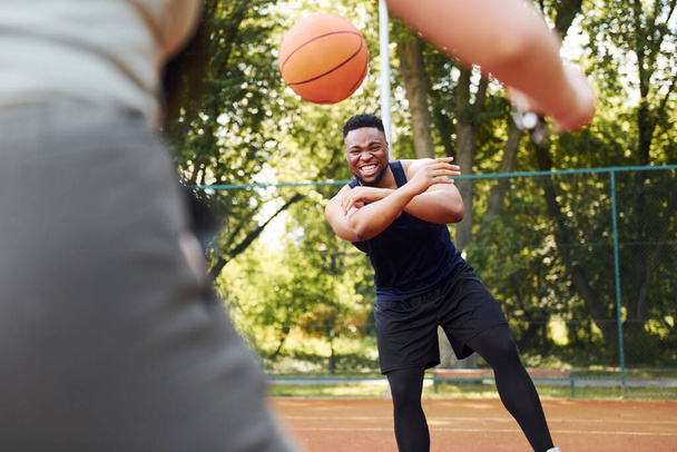 African american man with girl plays basketball on the court outdoors. - Fotoğraf, Görsel