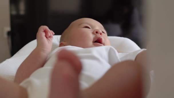Χαριτωμένο μωρό σε λευκό κρατώντας το χέρι μητέρες και να μιλήσει μαζί της - Πλάνα, βίντεο