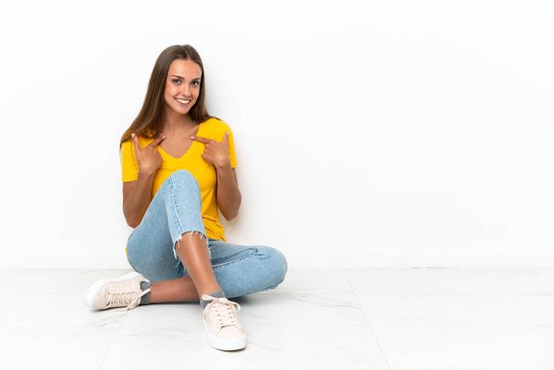 Young girl sitting on the floor with surprise facial expression - Foto, Bild