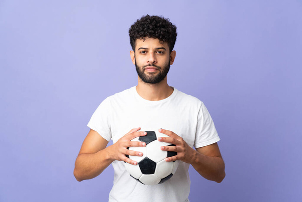 Jeune homme marocain isolé sur fond violet avec ballon de football - Photo, image