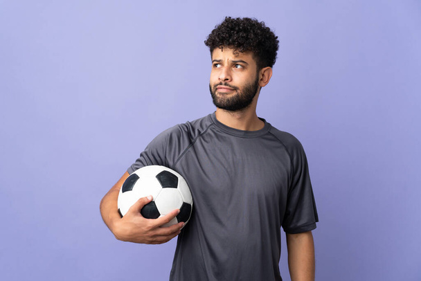 Bonito marroquino jovem jogador de futebol homem sobre isolado no fundo roxo pensando uma ideia ao olhar para cima - Foto, Imagem