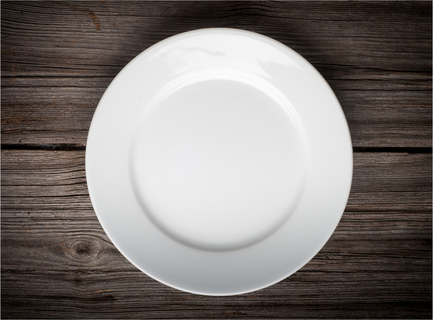 Empty white plate on wooden table - Valokuva, kuva