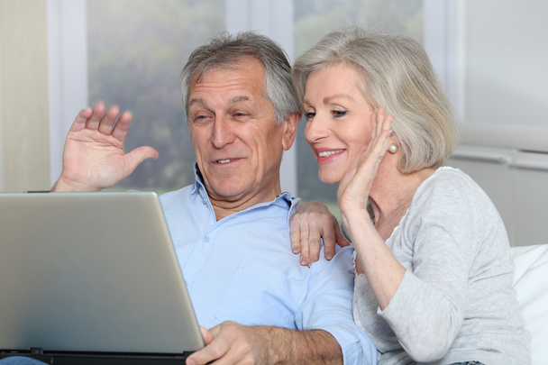 Senior couple waving at web camera - Фото, изображение