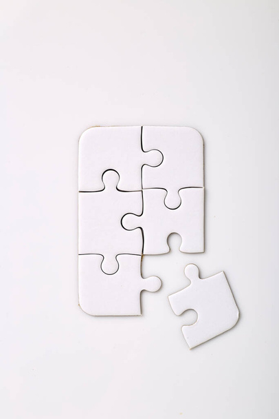 Cztery białe puzzle na białym tle pięć z nich jest już połączone Brakuje jeszcze jednego kawałka, aby dołączyć - Zdjęcie, obraz