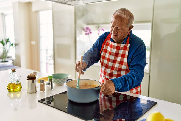 Homem sênior cozinhar espaguete na cozinha - Foto, Imagem