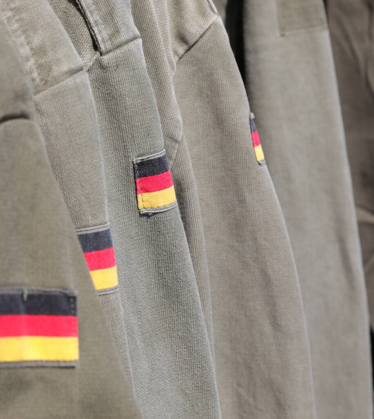 багато військового зеленого піджака з прапором Німеччини в рукаві костюма - Фото, зображення