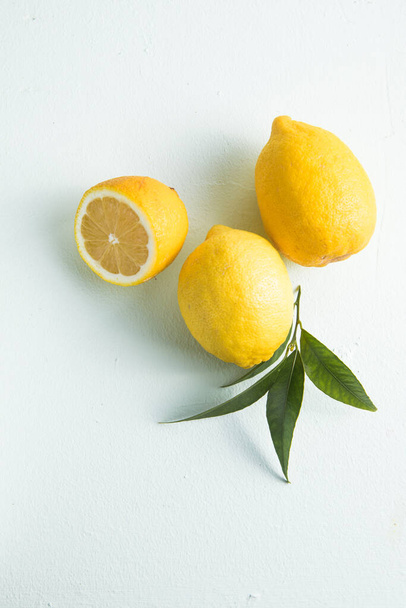 Mitades de limón y limón entero, con poca sombra. Fondo alimentario saludable. - Foto, imagen