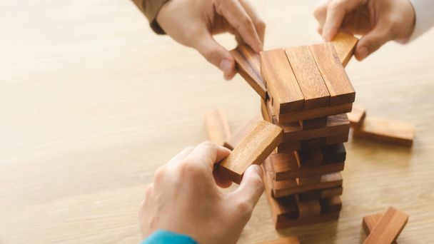 Business management concepten en business strategieën, een team van jonge genieën die houten spelletjes spelen, uitdrukking geven aan corporate visie, risico 's van toekomstige crises voorkomen. - Foto, afbeelding