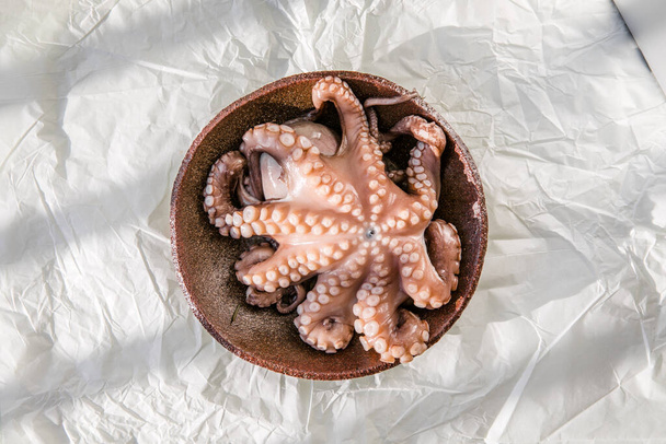La pieuvre est crue, prête à cuire. Concept créatif de nourriture saine avec des photos de délicieux fruits de mer - Photo, image