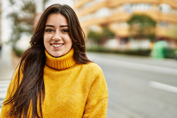 Giovane bella donna bruna che indossa maglione dolcevita sorridente felice all'aperto - Foto, immagini