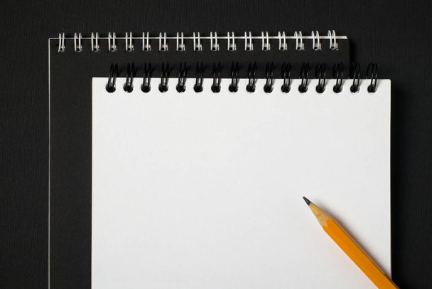 Quaderno con raccoglitore a spirale e matita su sfondo scuro, vista dall'alto, copiare spazio. Business o istruzione concetto minimo - Foto, immagini