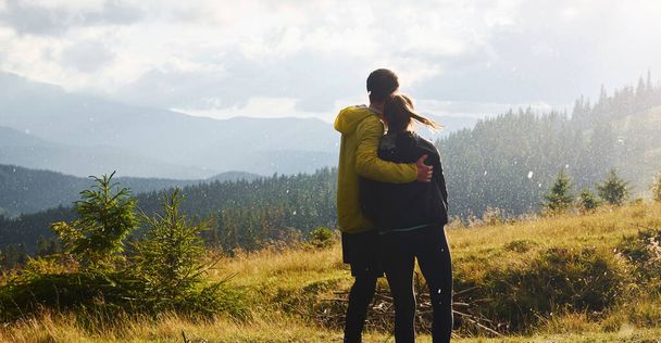 Girlfriend with her boyfriend embracing each other. Majestic Carpathian Mountains. Beautiful landscape of untouched nature. - Photo, image