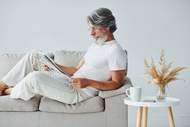 Having free time. Senior stylish modern man with grey hair and beard indoors. - Foto, Bild