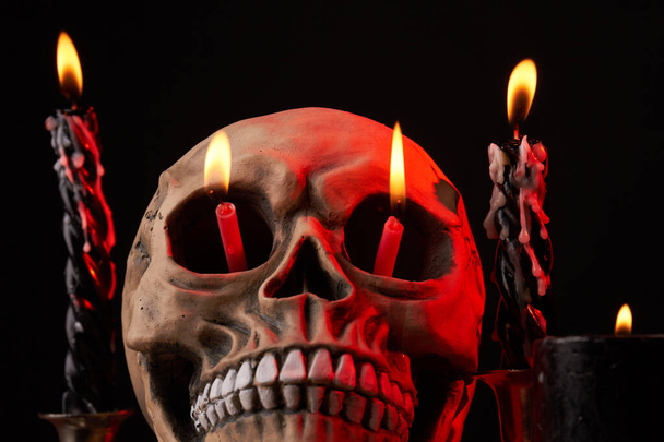 Κοντινό πλάνο ανθρώπινο κρανίο με φλόγες κερί στα μάτια του. - Φωτογραφία, εικόνα