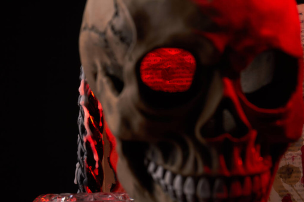 Close-up creepy humans skull with red lighting on black background. - Photo, Image