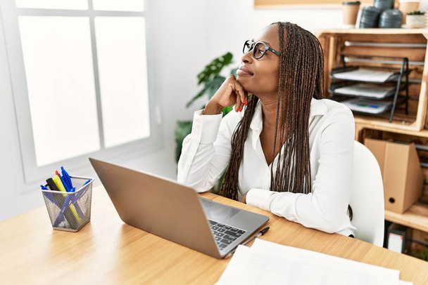 Молодая африканская американская бизнесвумен улыбается счастливой работе в офисе. - Фото, изображение