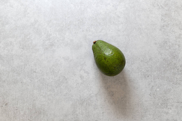 avocado fruit on a light gray background, space for text, top view - Zdjęcie, obraz