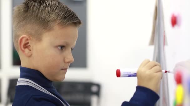 Junge schreibt in der Schule an Tafel, löst Aufgaben - Filmmaterial, Video