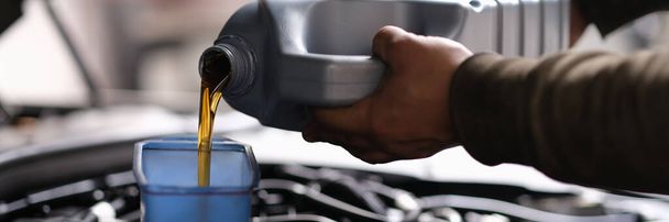 Mann schüttet Öl aus Kanister ins Auto - Foto, Bild