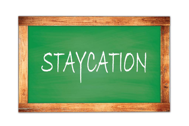 STAYCATION text written on green wooden frame school blackboard. - Photo, Image