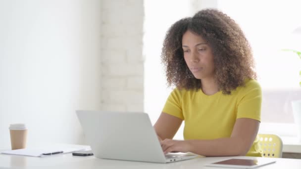 Mujer africana tiene dolor de cabeza mientras trabaja en el ordenador portátil - Imágenes, Vídeo