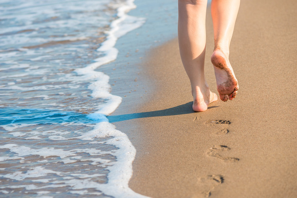 formás női lábak hagyja lábnyomok egy homokos strand - Fotó, kép