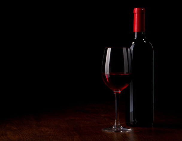 Bicchiere di vino e bottiglia su un tavolo di legno
 - Foto, immagini