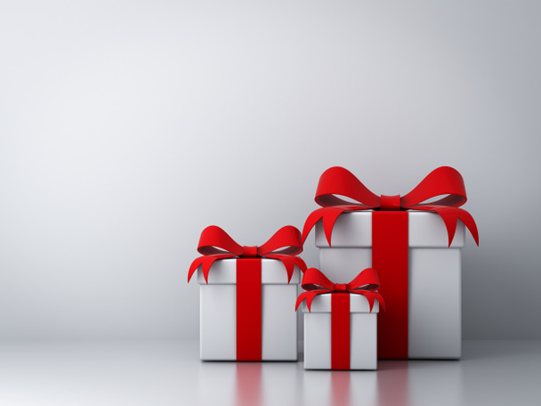 Cajas de regalo con lazo de cinta roja y pared blanca vacía
 - Foto, imagen